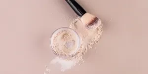 A glass jar with loose powder makeup