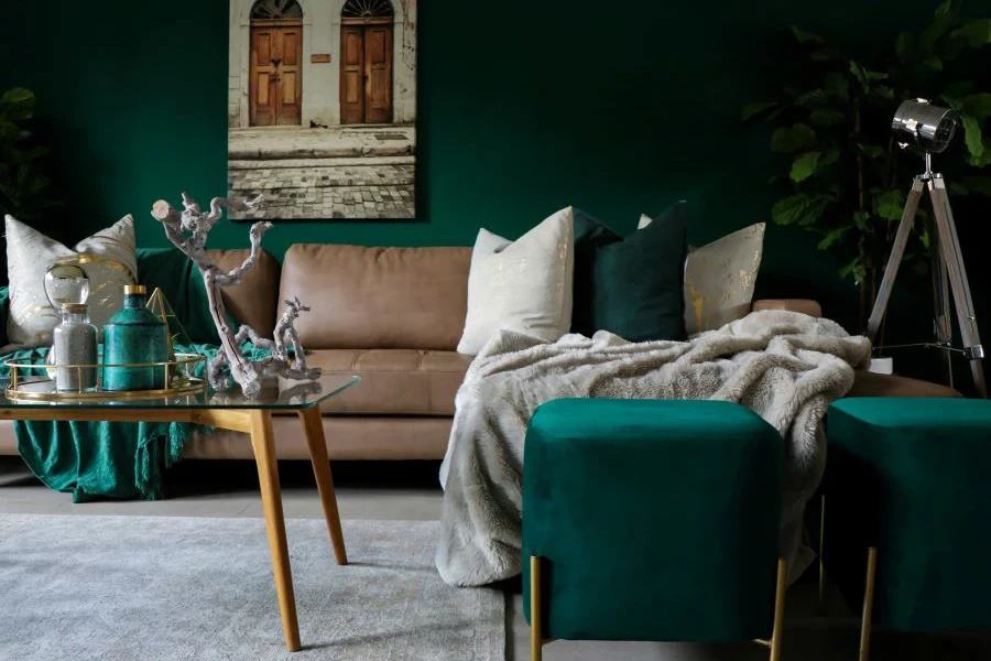 A living room painted emerald green with a green couch