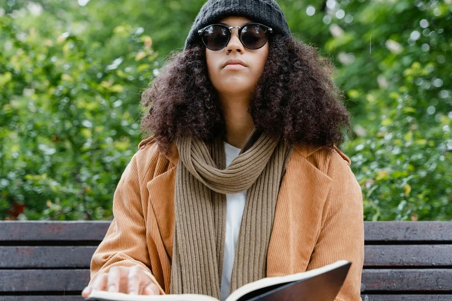 A woman wearing a brown corduroy blazer and sunglasses