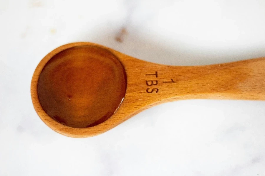 A wooden spoon with a liquid in it