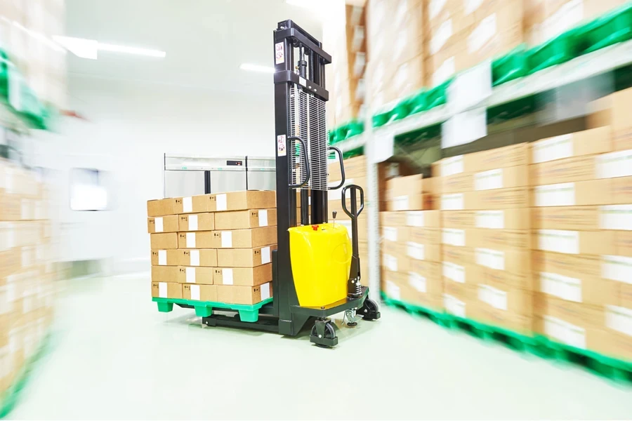 An electric stacker arranging pallets in a stockroom