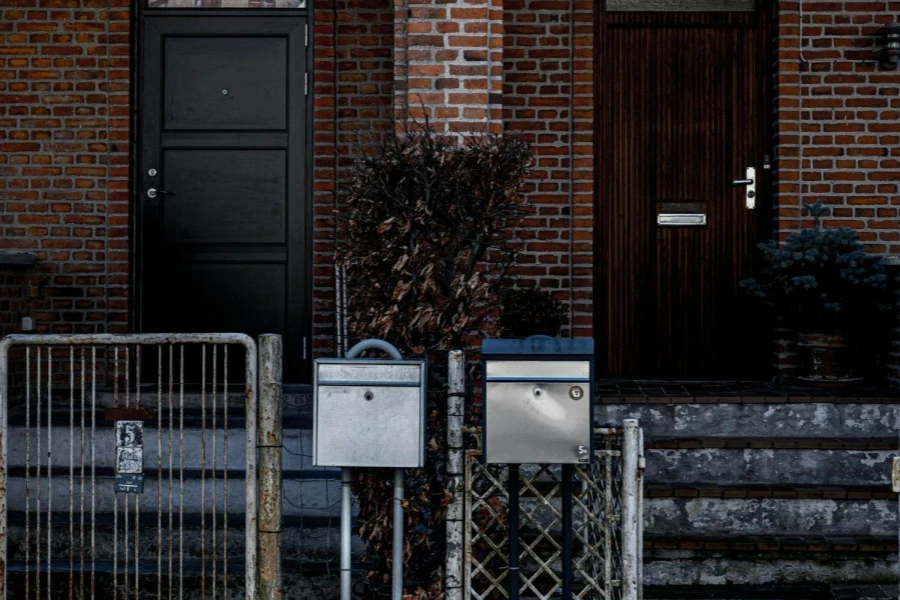 Donkere houten voordeuren bij de ingang van het huis met bakstenen muren aan de buitenkant