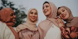 Four women wearing different hijab styles and laughing together