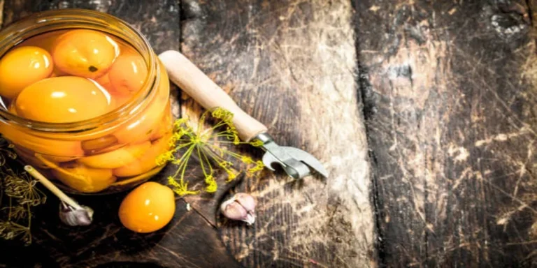 Glass jar of peaches with jar opener beside it