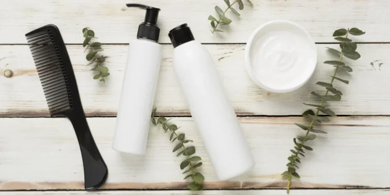 Hair care products and comb on a wooden background