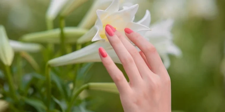 Hand with nail touching flower