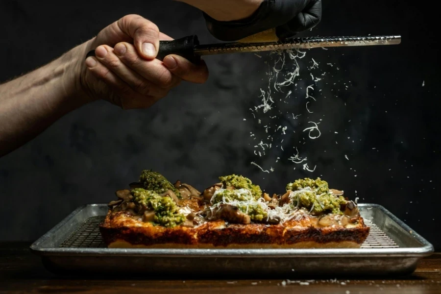 Man Grinding Cheese over Meal