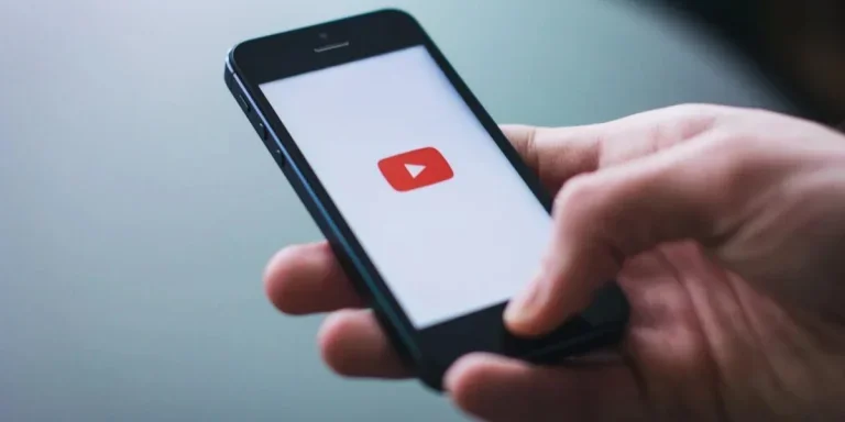 Man holding a phone with a YouTube app