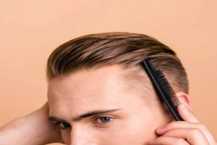 Hombre usando un peine de dientes finos para peinar el cabello hacia atrás