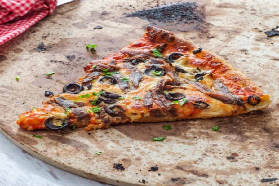 Single slice of vegetarian pizza sitting on pizza stone