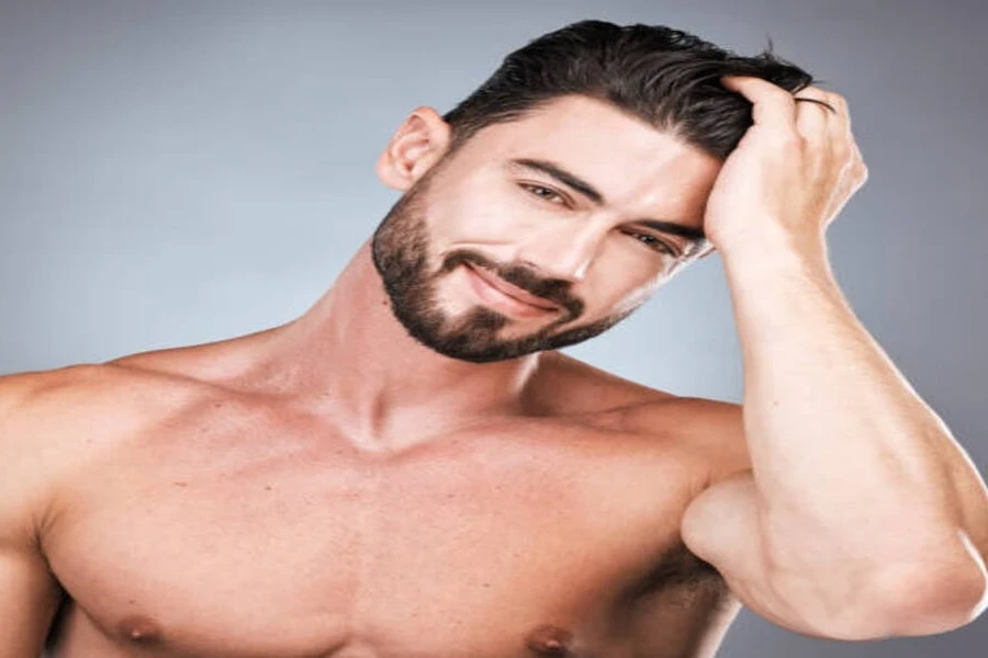 Hombre fuerte con barba y cabello texturizado peinado hacia atrás