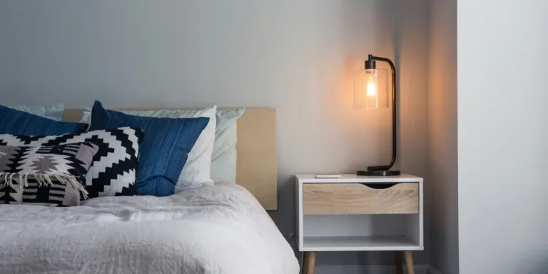 Table lamp on nightstand next to bed