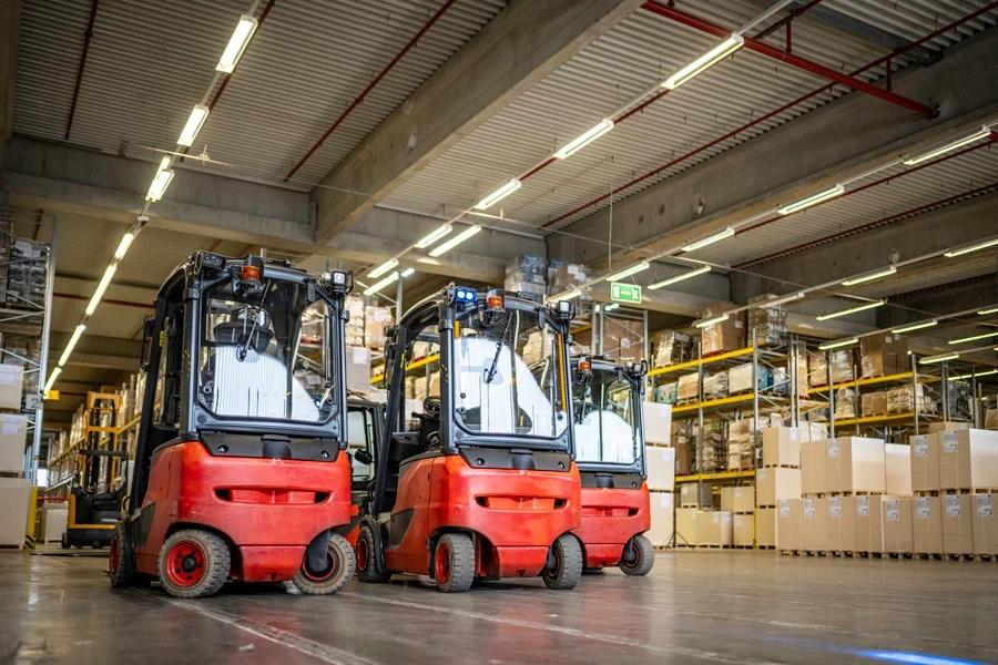 Three empty forklift trucks in a warehouse