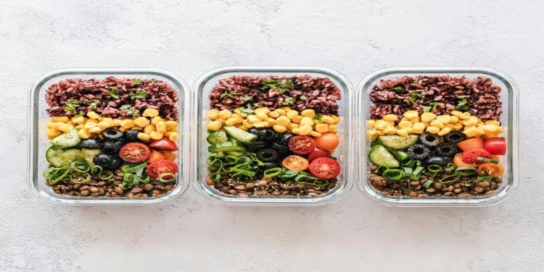 Three glass meal prep containers with healthy meals inside