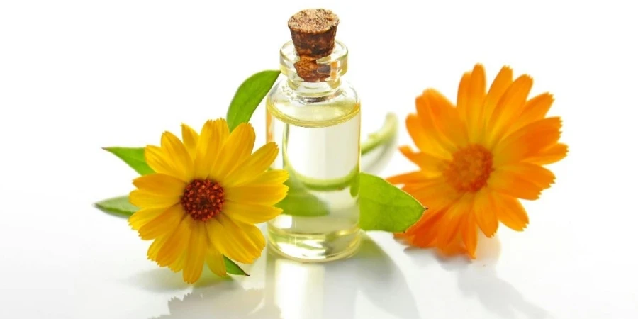 Two Yellow Sunflowers With a Clear Glass Bottle With a Cork Lid