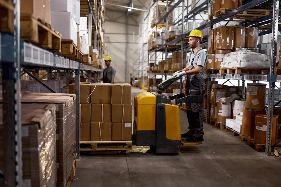 Warehouse worker using an electric pallet truck