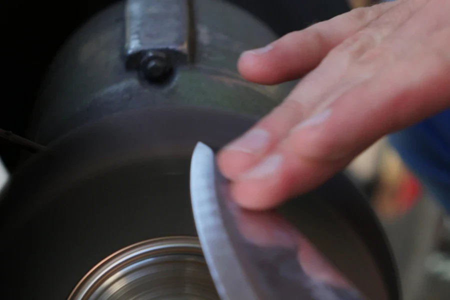 a person sharpening a knife of a disk