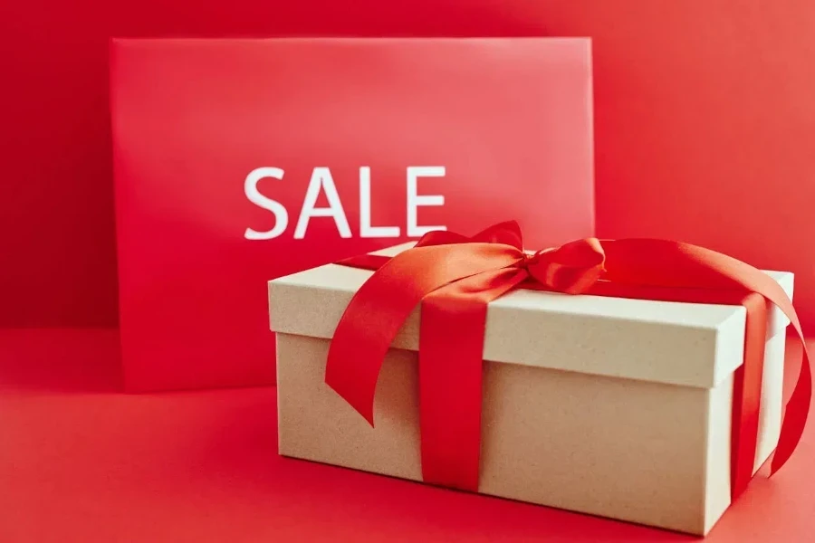 a sale sign placed beside a box with a red ribbon