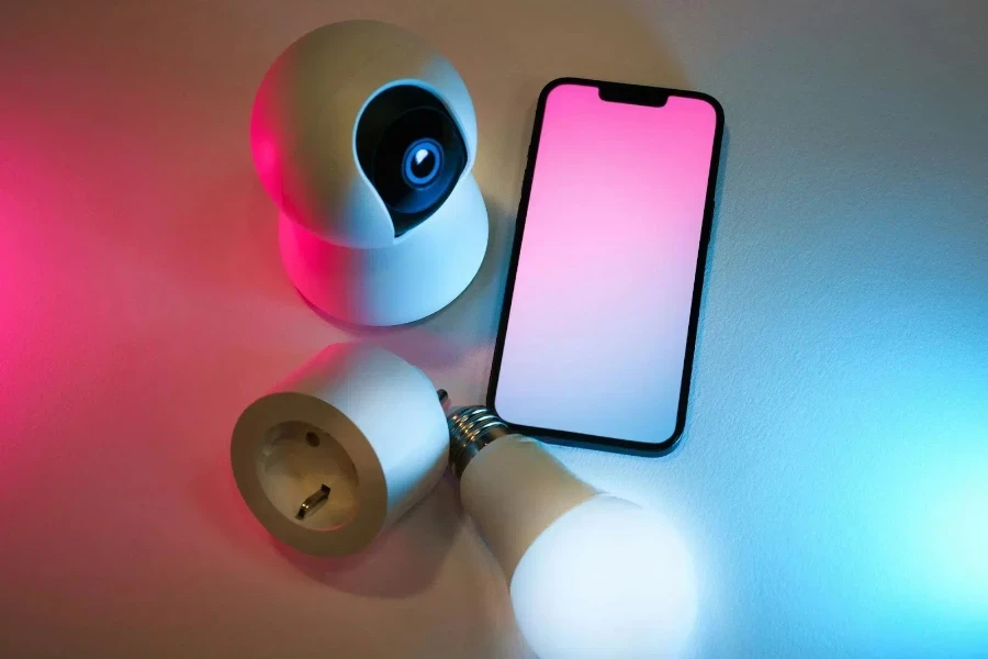 A smartphone, camera and lights are on a white table