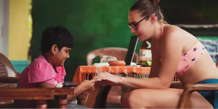 A woman sitting near a child and holding hands