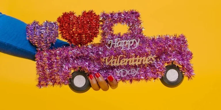 hands holding a valentine’s gift shaped like a car