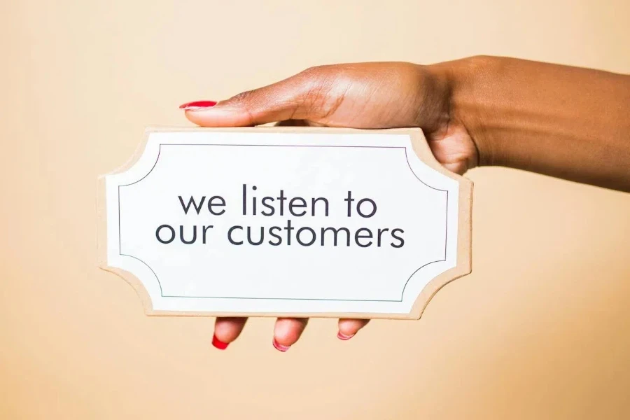 Person holding a board with “we listen to our customers” text