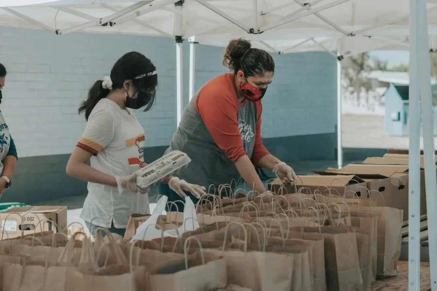 Person in red t-shirt looking at paper bags