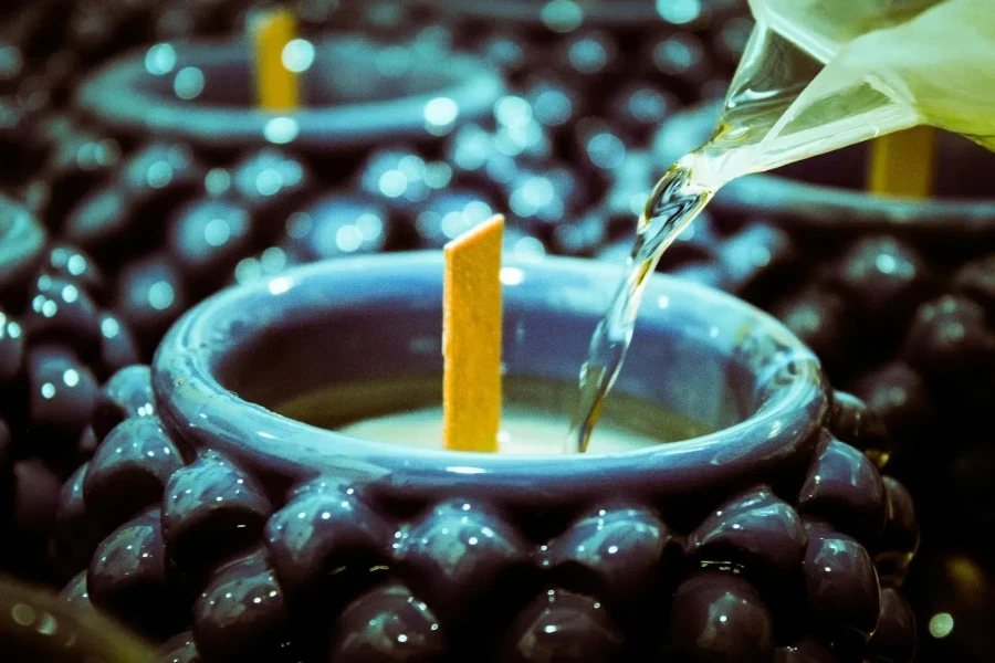 Person pouring liquid wax on a candle mould