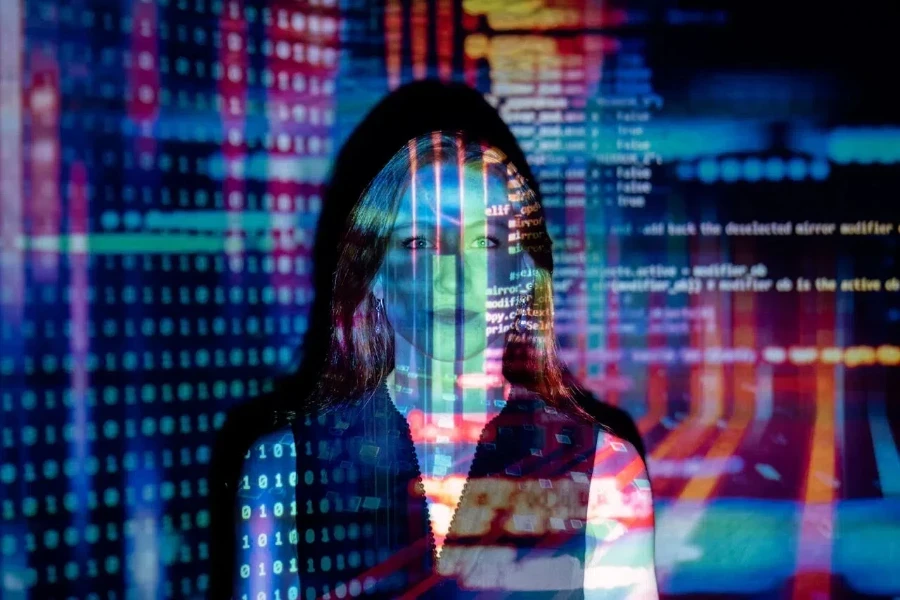 woman illuminated by colorful digital code projections