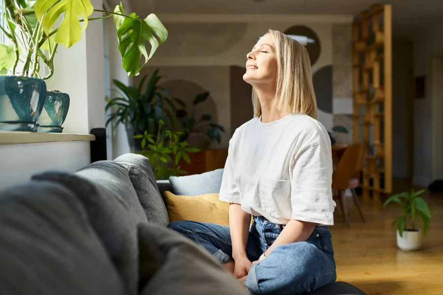 woman in a relaxing, serene interior with 2025 home decor trends