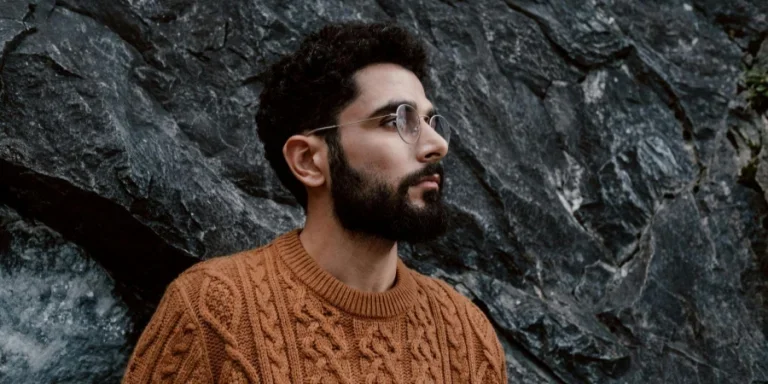 Бородатый мужчина в коричневом вязаном свитере
