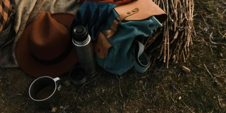 Eine Nahaufnahme einer Isolierflasche neben einer Tasche