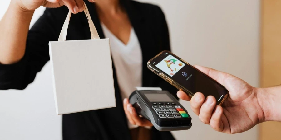 A Person Using Mobile Phone to Pay Cashless