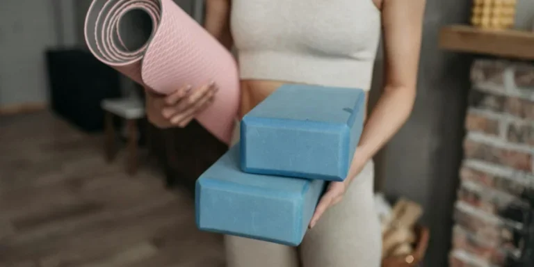 A Woman Holding Pillows and Mat Used for Exercising