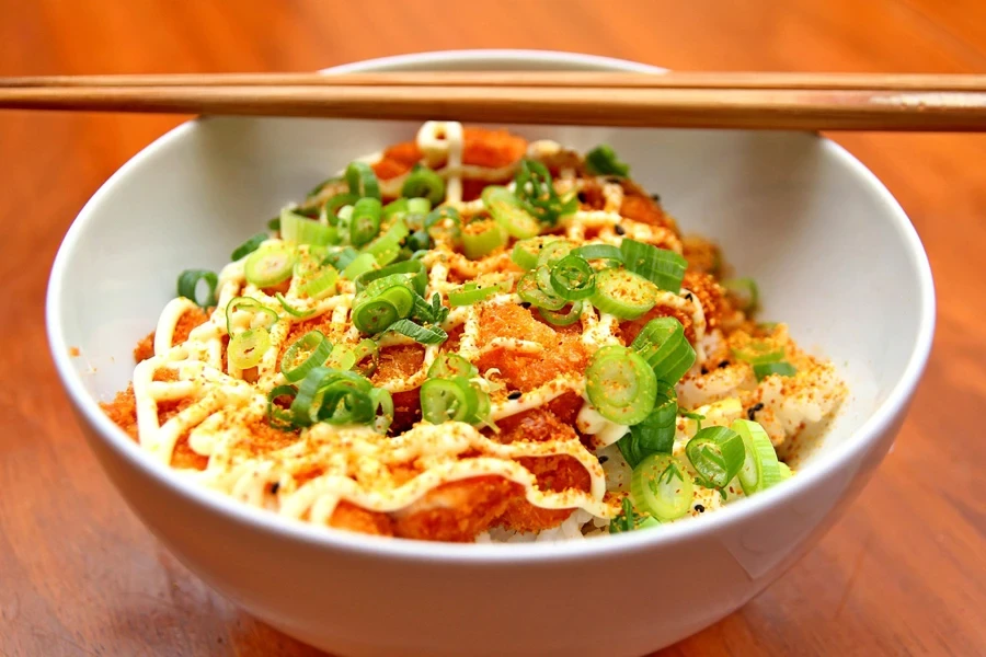 A bowl of food with chopsticks