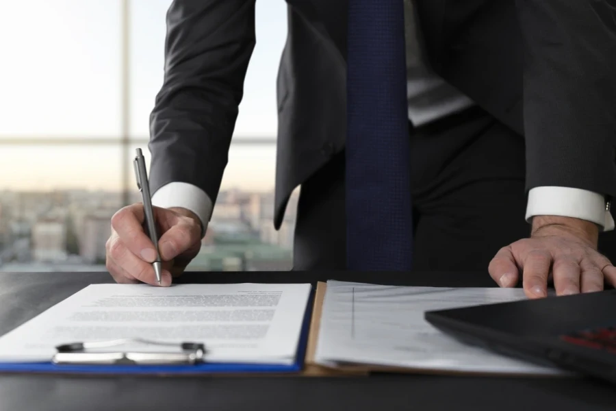 A businessman signing papers to register his brand