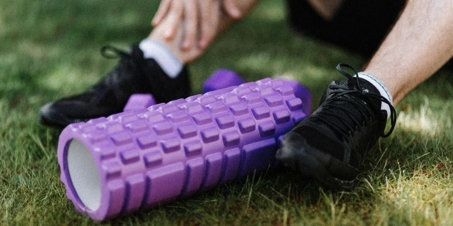 A close-up of a person's feet and a purple foam roller