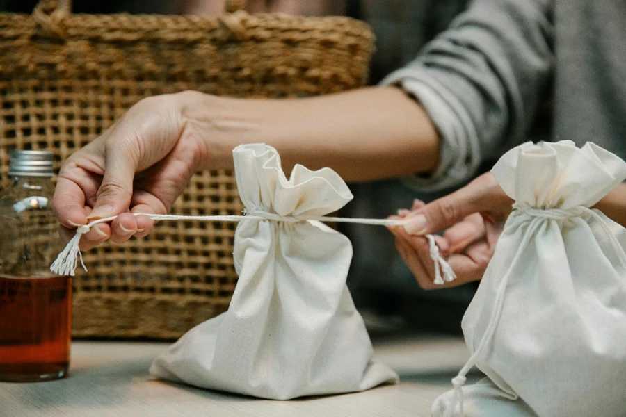 A close-up of hands pulling a string of a bag