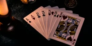A dimly lit close-up of playing cards with a pocket watch, showcasing a nostalgic casino vibe