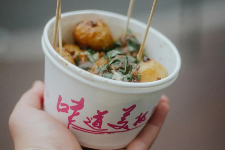A hand holding a bowl of food