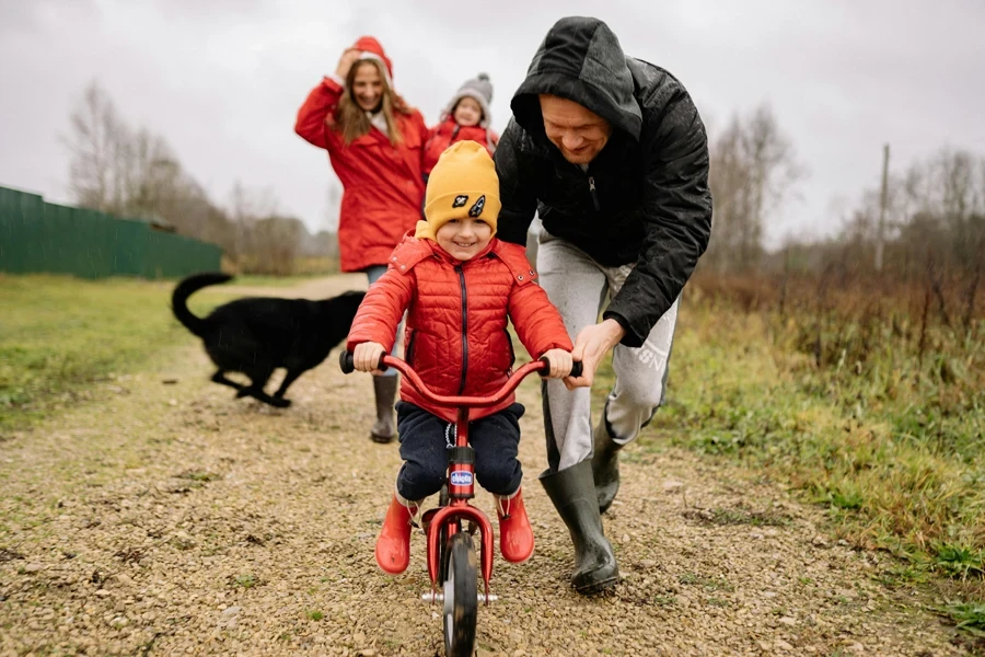 A joyful scene of a father helping his child ride a bike outdoors