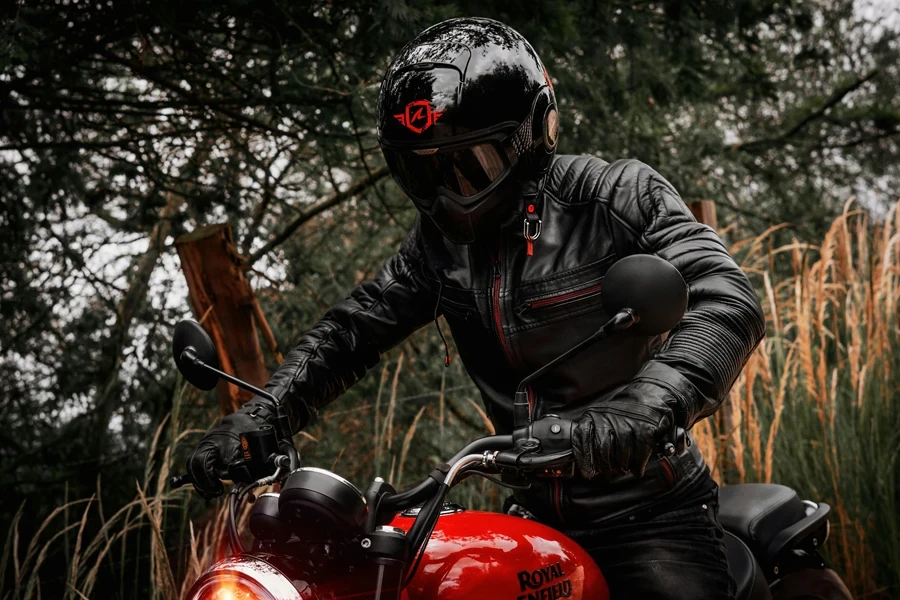 A motorcyclist in black leather gear rides through a scenic outdoor setting in Bogotá, Colombia