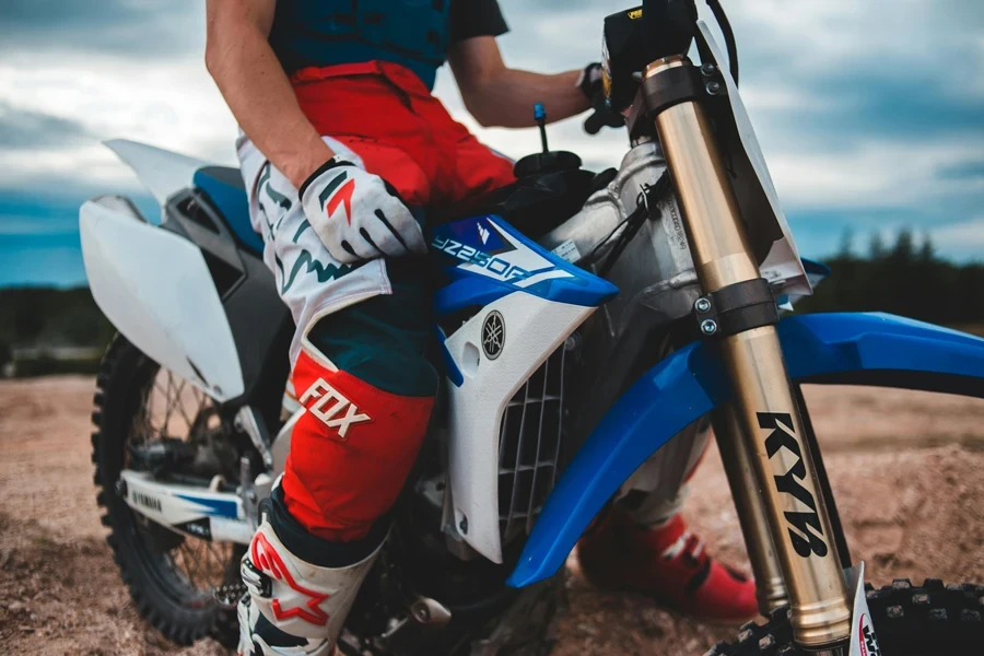 A motorcyclist sitting on a blue enduro bike, ready for action in a natural setting