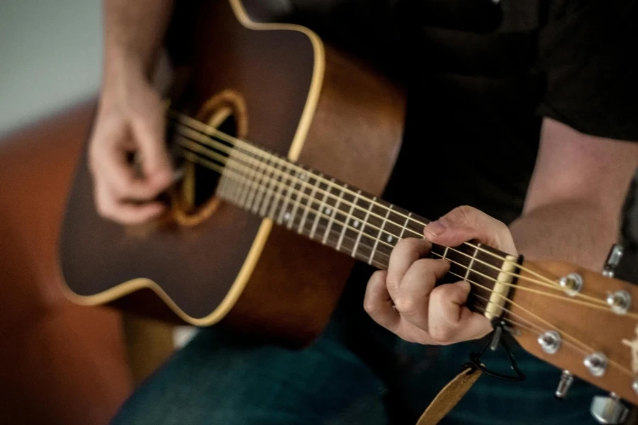 A musician strums chords on an acoustic guitar, showcasing musical talent