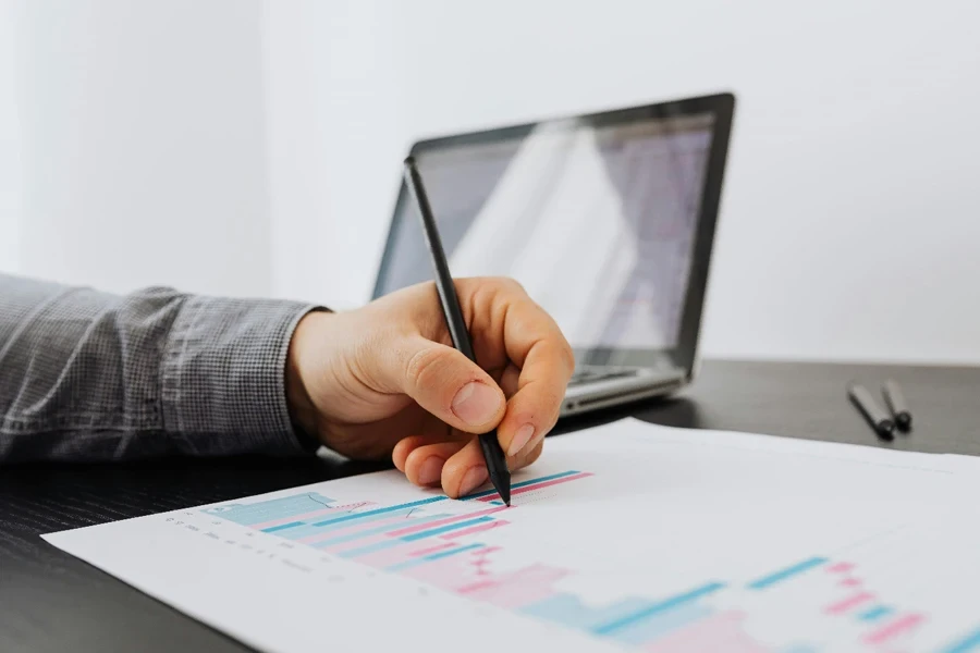 A person holding a pen over a graph