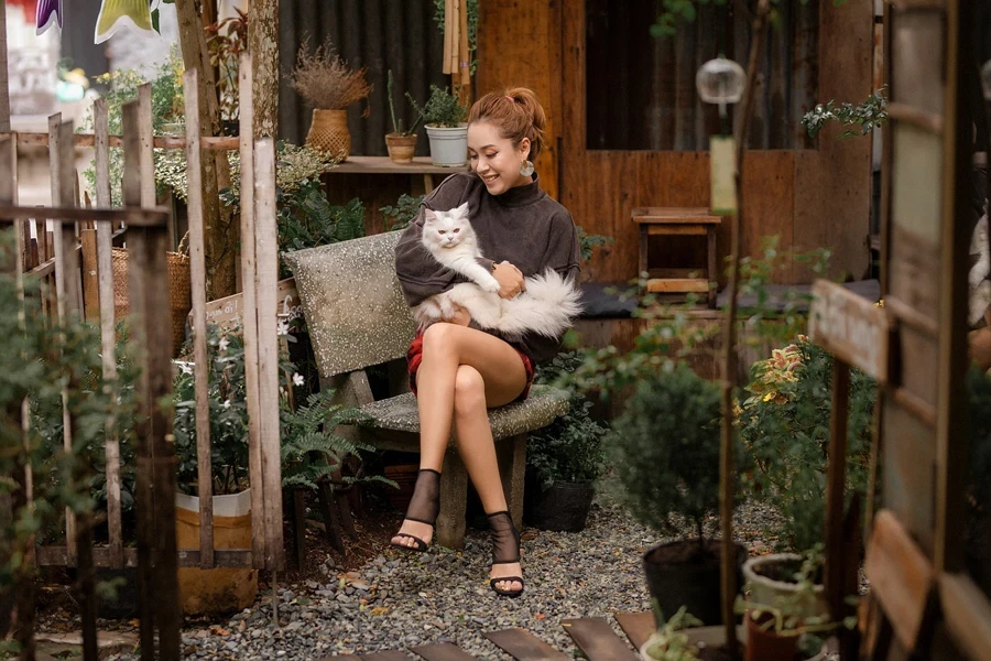 A person sitting on a bench holding a cat