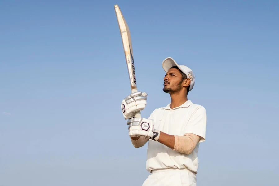 A person wearing white clothes holding a bat