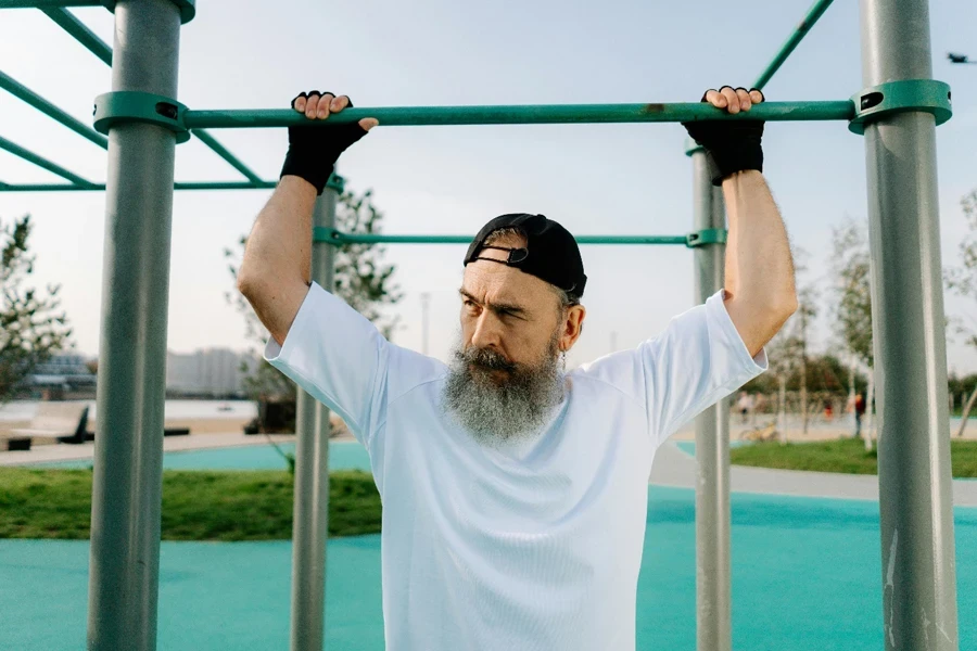 A person with a beard holding up a bar