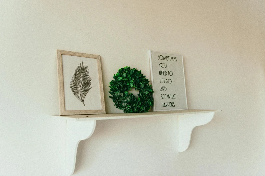 A shelf with pictures and a wreath on it