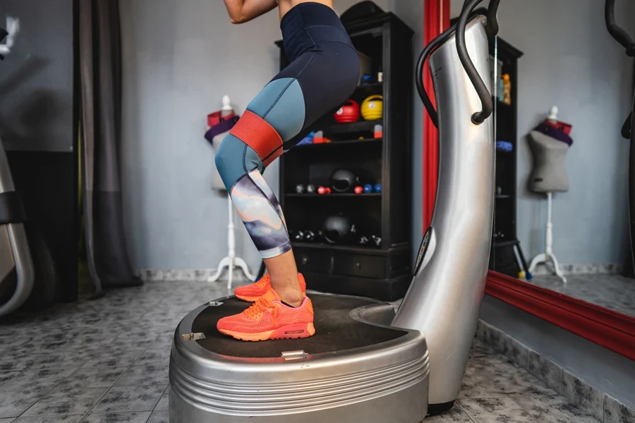 A woman standing on a vibration plate exercise machine